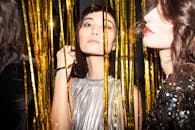 成年女性们在充满活力的夜间派对上，身着金色装饰，展示时尚，庆祝活动