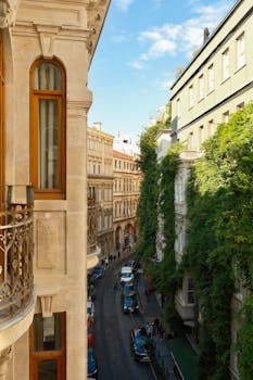 Scenic view of a European street lined with historic buildings and lush greenery.