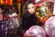 时尚女性在热闹的派对上拿着彩色气球摆姿势