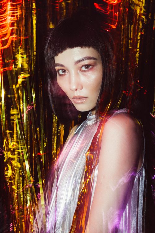 Free Creative portrait of a stylish young woman with vibrant lighting effects. Stock Photo