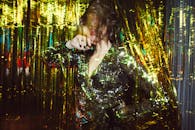 一位穿着亮片连衣裙的时尚女性在耀眼的光径中摆出姿势，捕捉现代艺术氛围