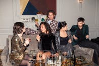 一群穿着正式的成年人正享受着热闹的派对，现场有饮料，也有笑声