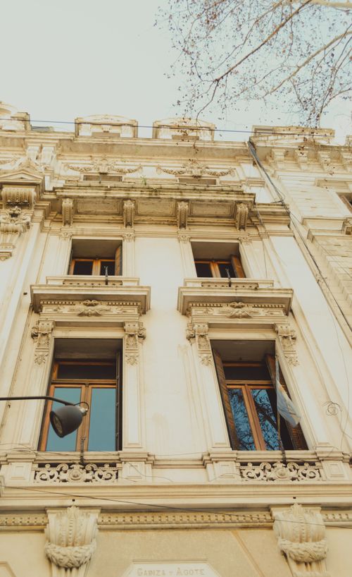 Free Elegant facade of historic European building with large windows and intricate details. Stock Photo