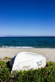 白色的船倒在希腊哈尼奥蒂的沙滩上，蔚蓝的天空下
