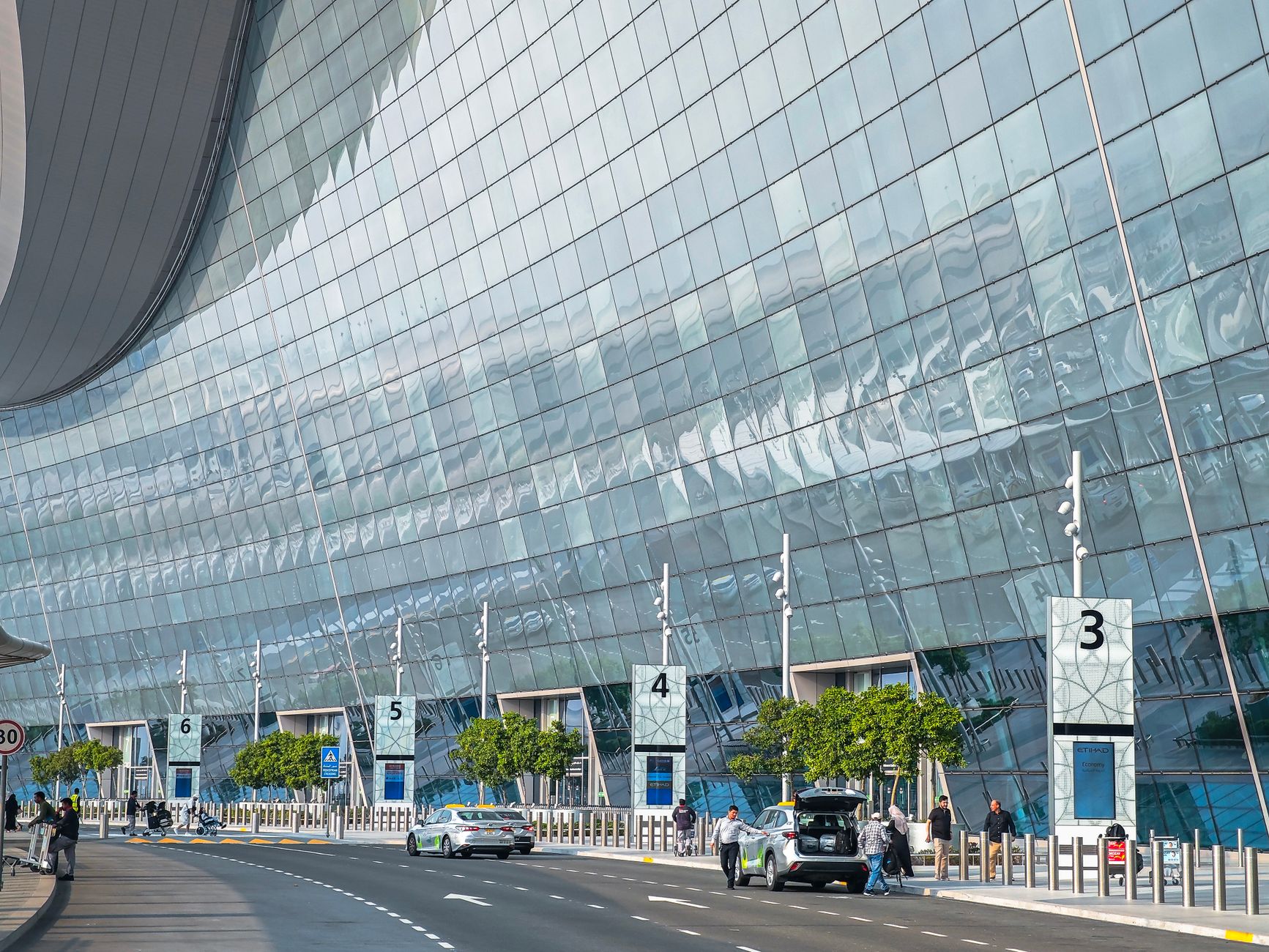 Stunning modern facade of an airport terminal in Abu Dhabi with reflective glass and contemporary design.