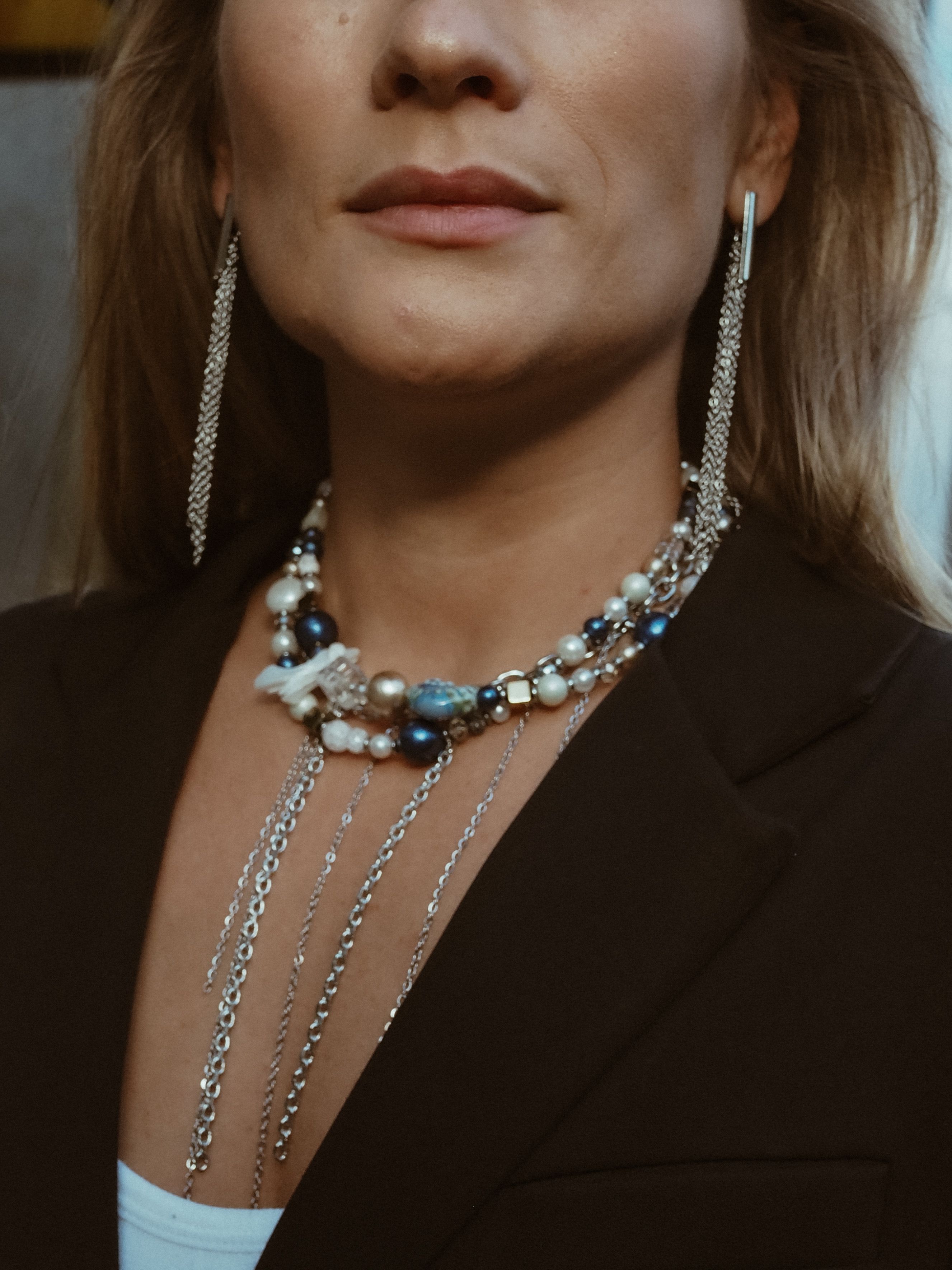 Free Close-up of a woman wearing stylish jewelry and a brown blazer, showcasing elegance. Stock Photo