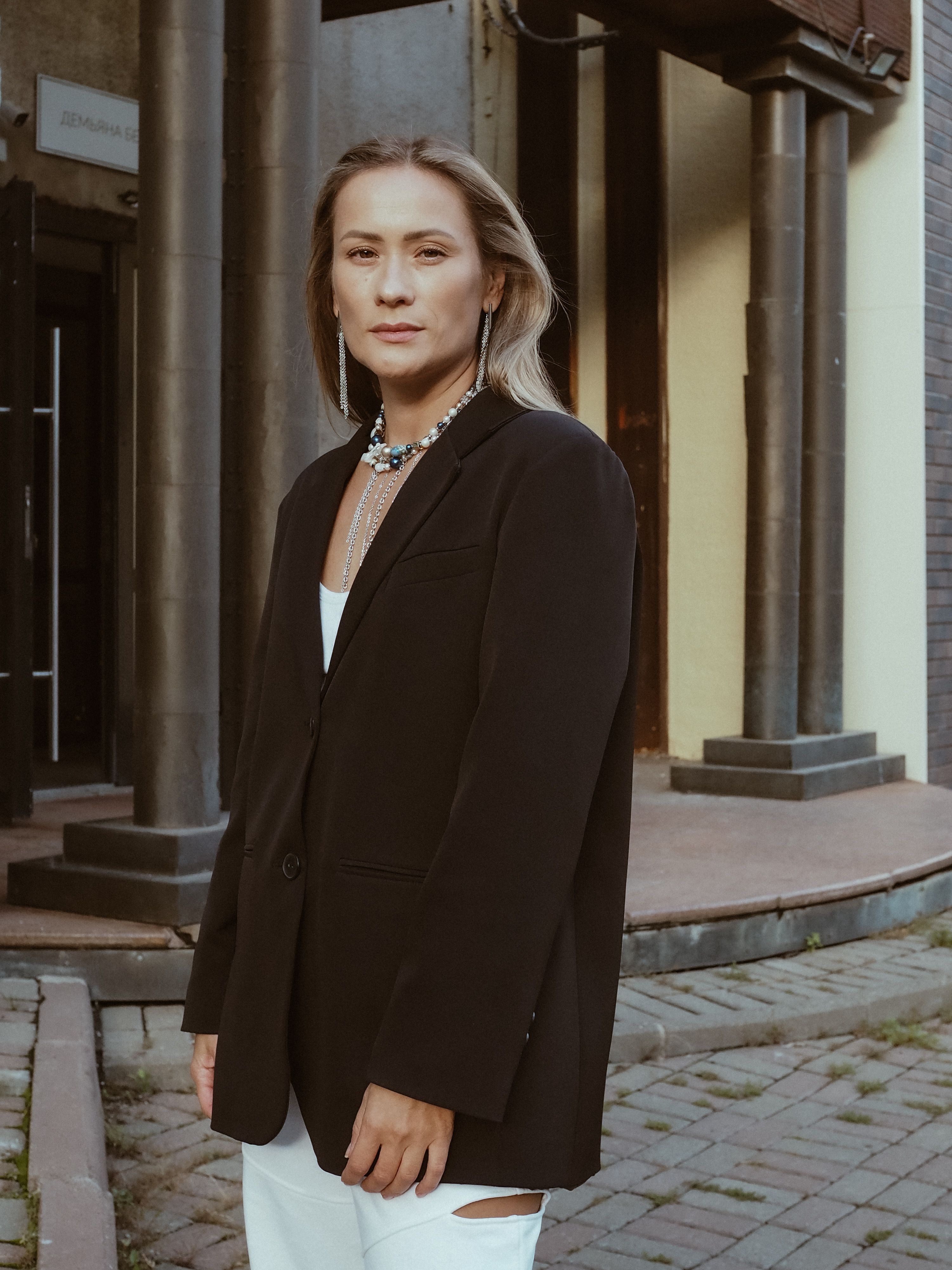 Free Stylish adult wearing a black blazer in an urban setting. Fashion forward look. Stock Photo