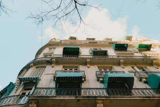 仰望一座复古城市建筑，其带有绿色遮阳篷的经典建筑风格令人瞩目