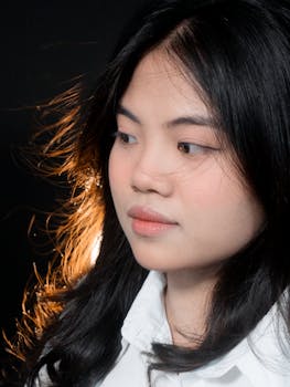 一位留着黑色长发、穿着白色衬衫的女性的工作室肖像