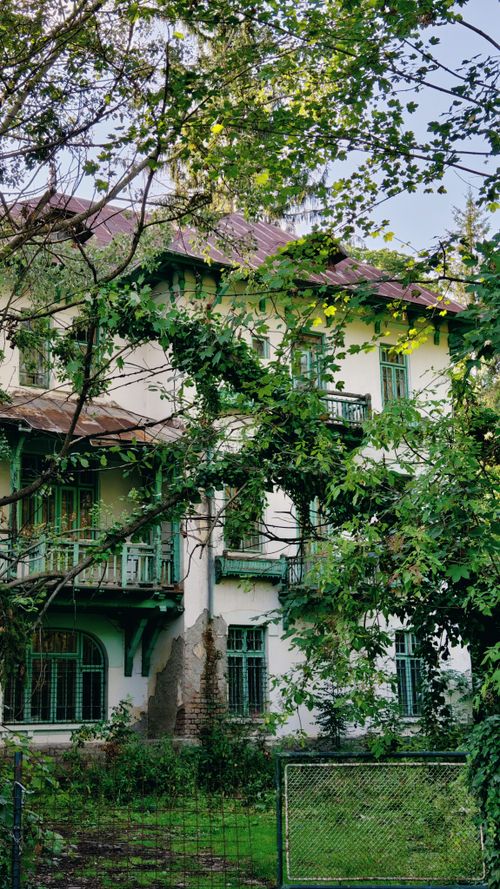 Free Discover a historic villa surrounded by lush greenery in scenic Sinaia, Prahova, Romania. Stock Photo