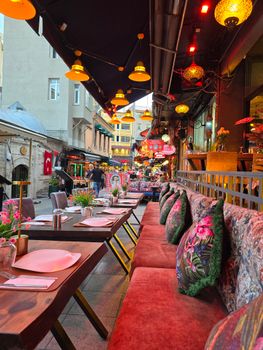 Charming outdoor café in Istanbul with decorated tables and vibrant street ambiance.