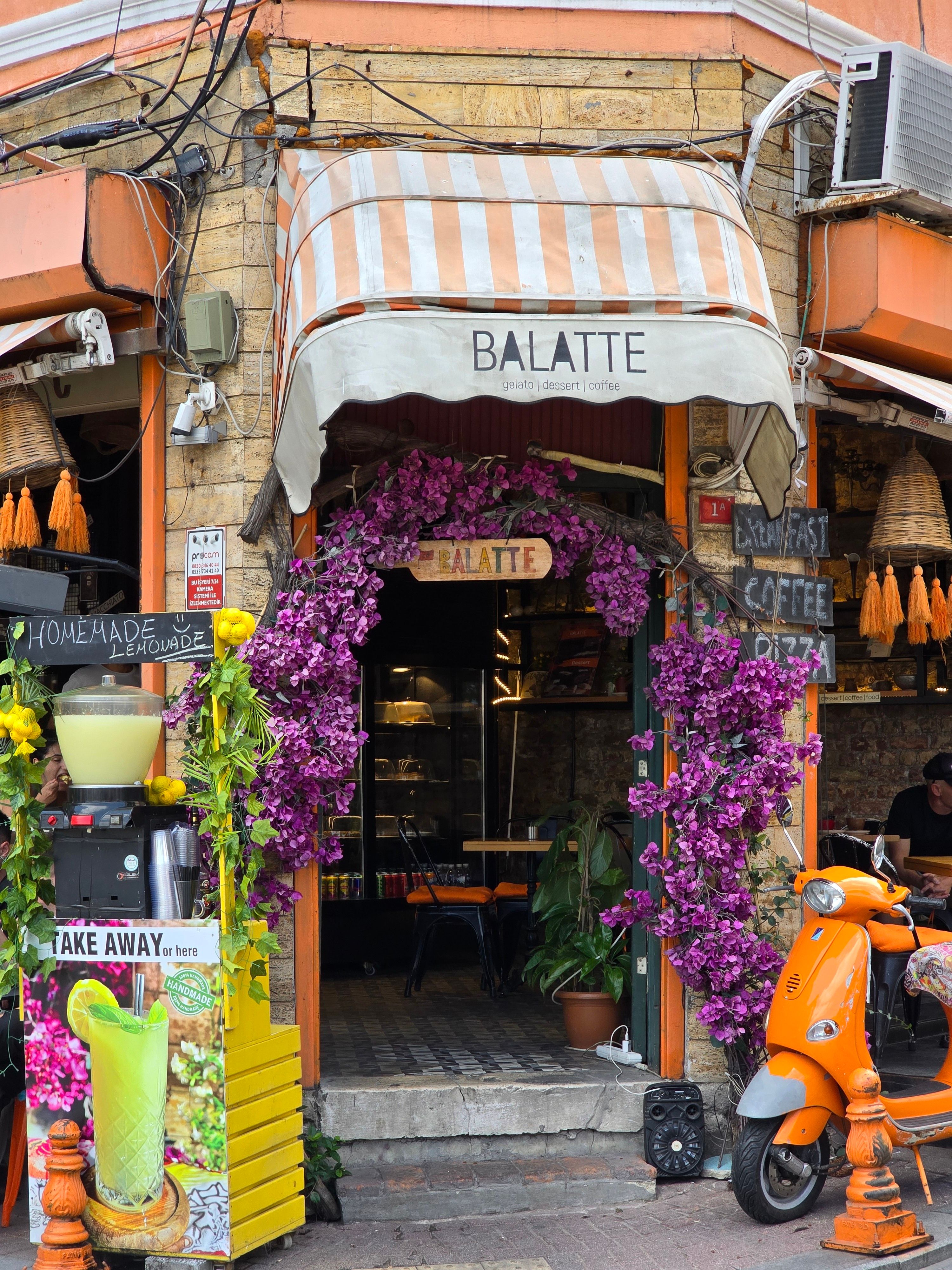 Colorful cafe entrance in Istanbul with flowers and retro scooter.