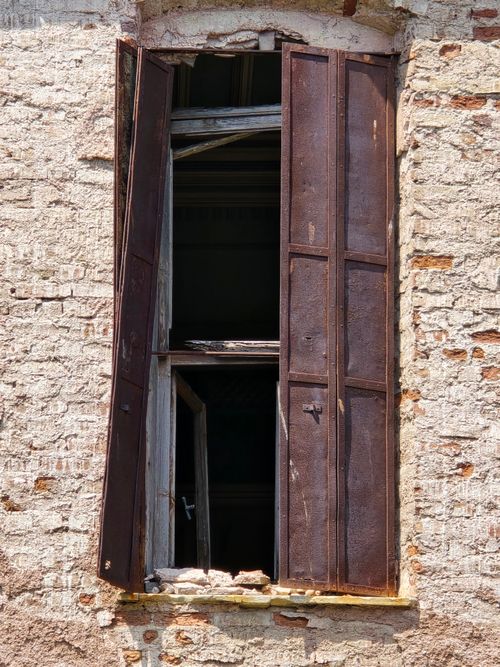 Free Close-up of a rustic window with aged shutters on a textured brick wall in Türkiye. Stock Photo
