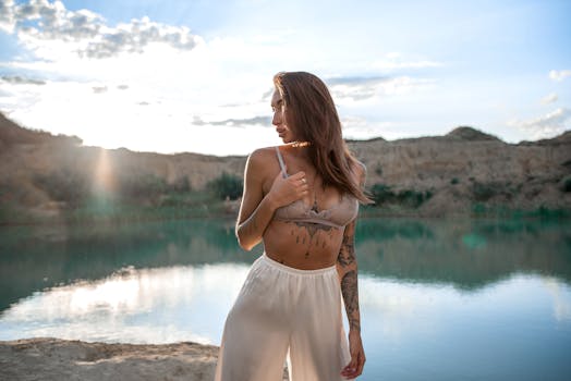 日落时分，年轻女子身穿夏装，站在宁静的湖边