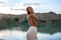 一个女人优雅地站在宁静的湖边，在日落时分散发着优雅和宁静