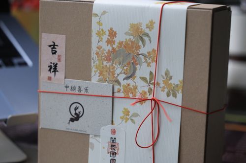 Free A beautifully wrapped gift box featuring floral design and Chinese calligraphy, perfect for festive occasions. Stock Photo