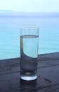 在木桌上，一杯高水静静地摆放着，背景是一片碧绿色的大海