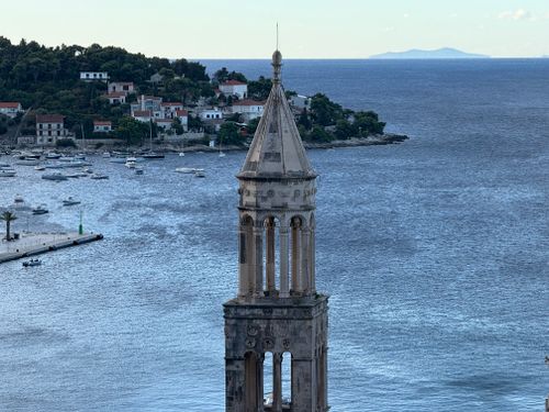 Free An ancient bell tower stands tall overlooking the serene Adriatic Sea with distant islands and coastal town. Stock Photo