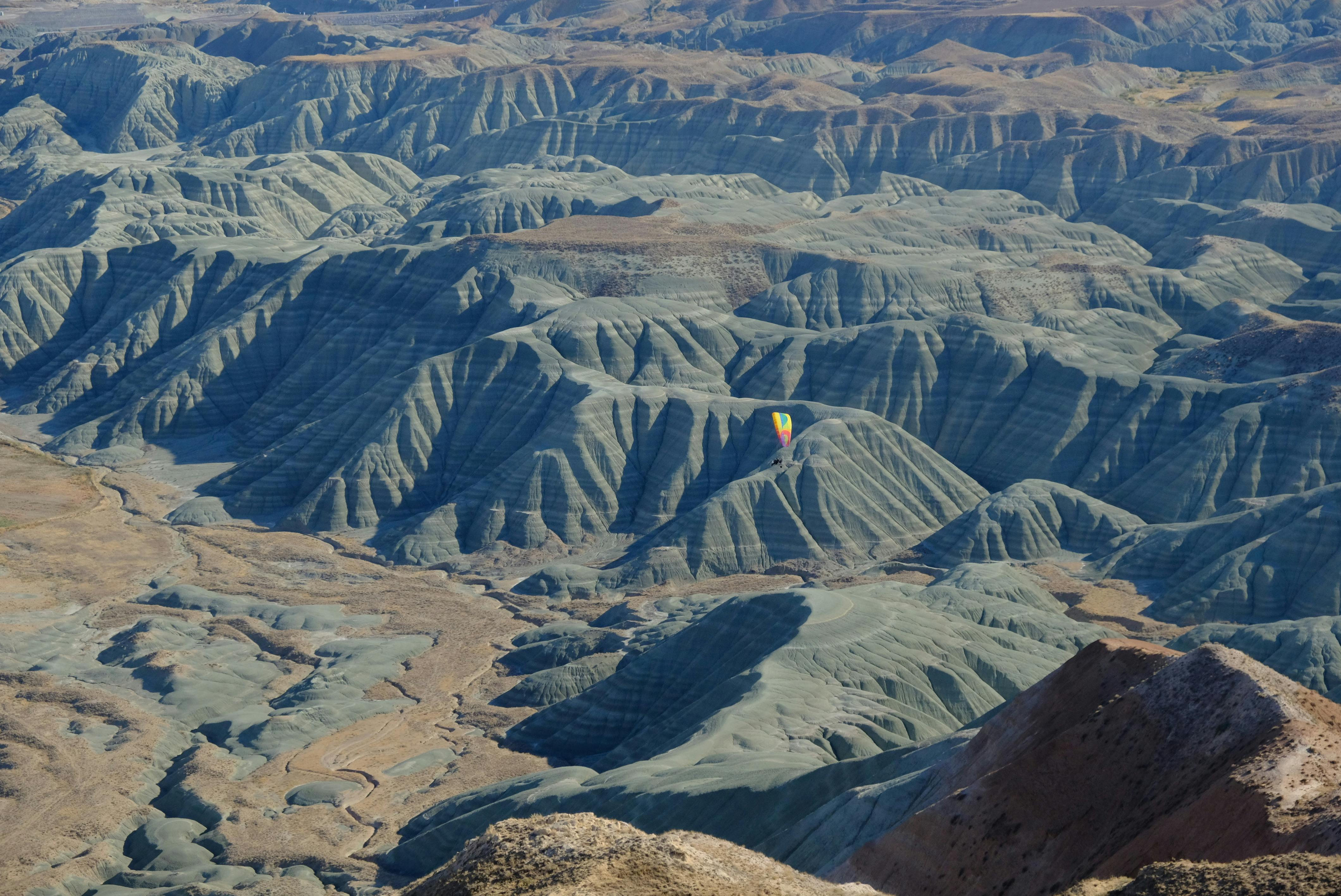 在分层的山地景观上，色彩缤纷的热气球展现出壮丽的景象，为观者提供了一幅迷人的鸟瞰图