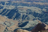 在分层的山地景观上，色彩缤纷的热气球展现出壮丽的景象，为观者提供了一幅迷人的鸟瞰图