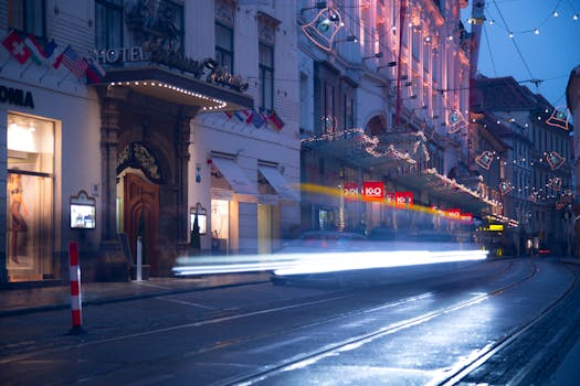 Urban street scene at twilight with light trails from moving vehicles, showcasing city life.