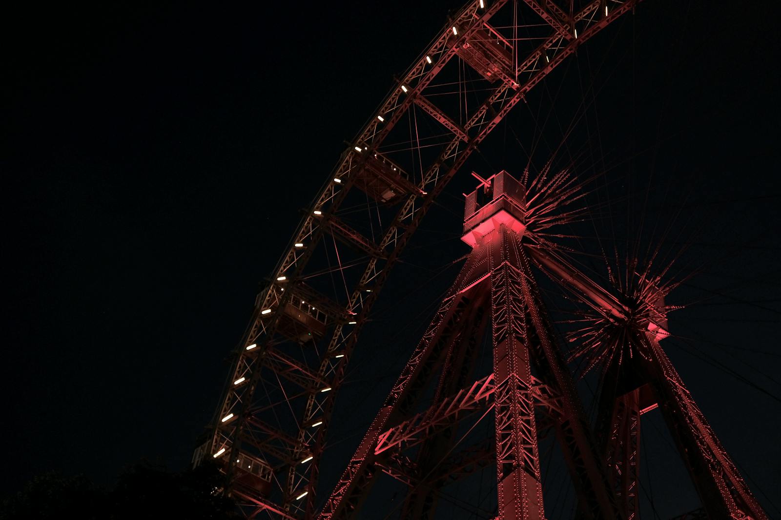 Illuminated ferris wheel at night with saturated colors and gentle glow