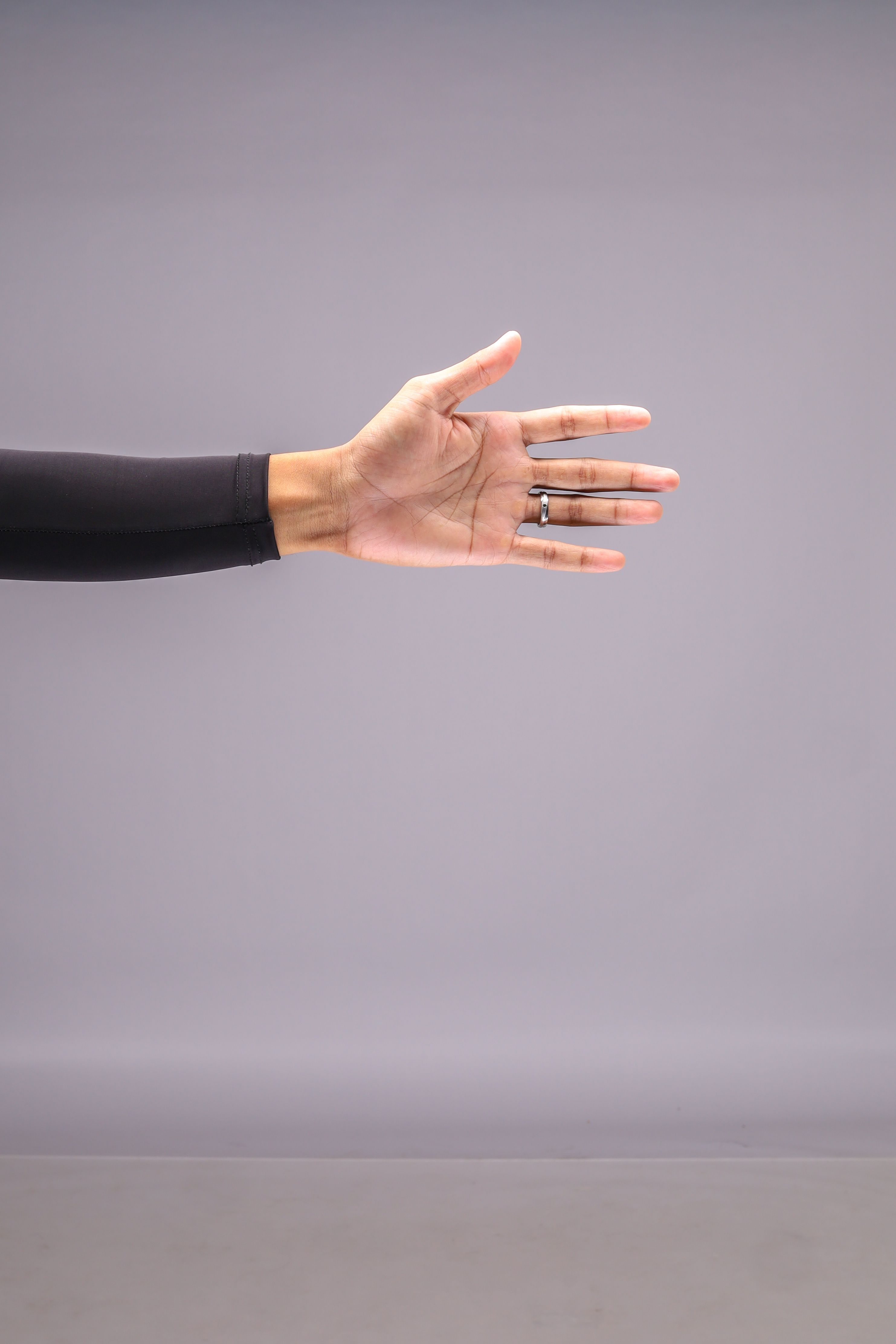 An open human hand with the thumb clearly visible against a grey background.