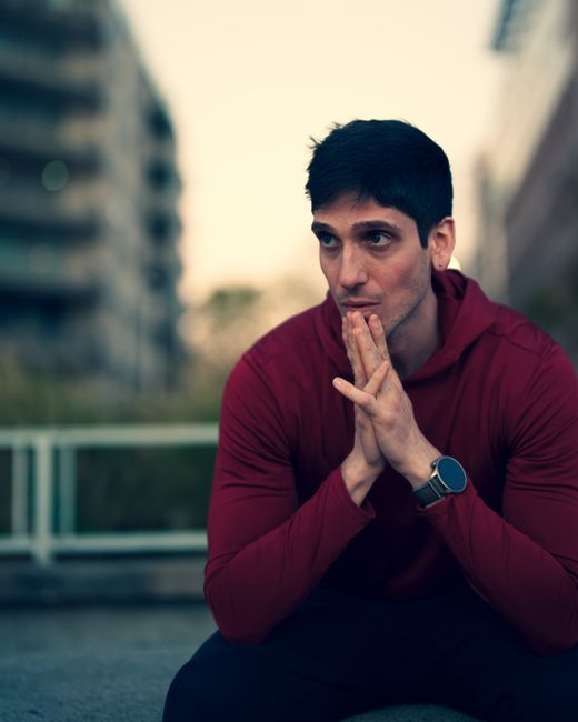 Thoughtful young man in red hoodie posing outdoors in Buenos Aires at dusk. Thoughtful young man in red hoodie posing outdoors in Buenos Aires at dusk.