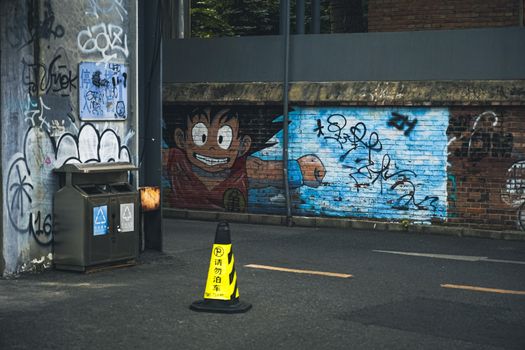 Colorful street art and graffiti on a brick wall in a Beijing alley, showcasing urban culture.