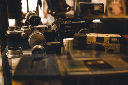 Free A collection of vintage cameras and photography equipment showcased in a display, highlighting retro aesthetics. Stock Photo