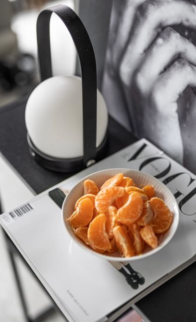 Elegant still life of peeled tangerines on a magazine, offering a modern lifestyle vibe.