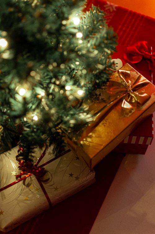 Free Close-up of Christmas presents and a decorated tree, highlighting festive cheer. Stock Photo