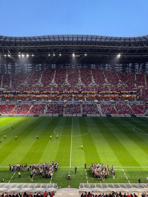 Free Exciting football match in a packed stadium with fans cheering under bright lights. Stock Photo