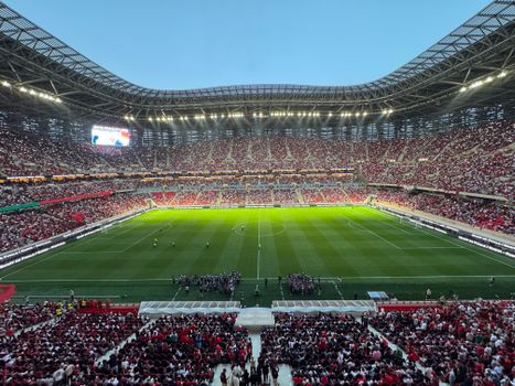 A packed football stadium in Morocco buzzing with excitement during a match, showcasing vibrant crowds and dazzling lights.