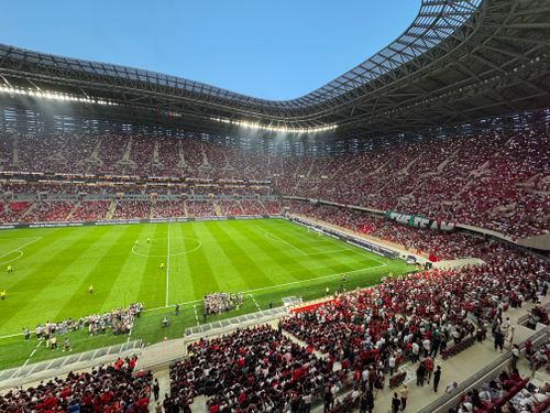 Free A vibrant football match with cheering fans in a modern stadium. Stock Photo