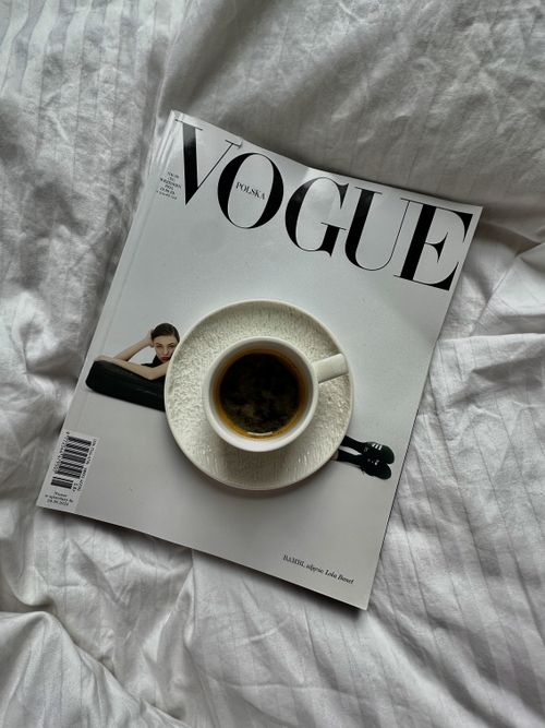 Free A Vogue magazine with a coffee cup placed on a bed, creating a cozy morning vibe. Stock Photo