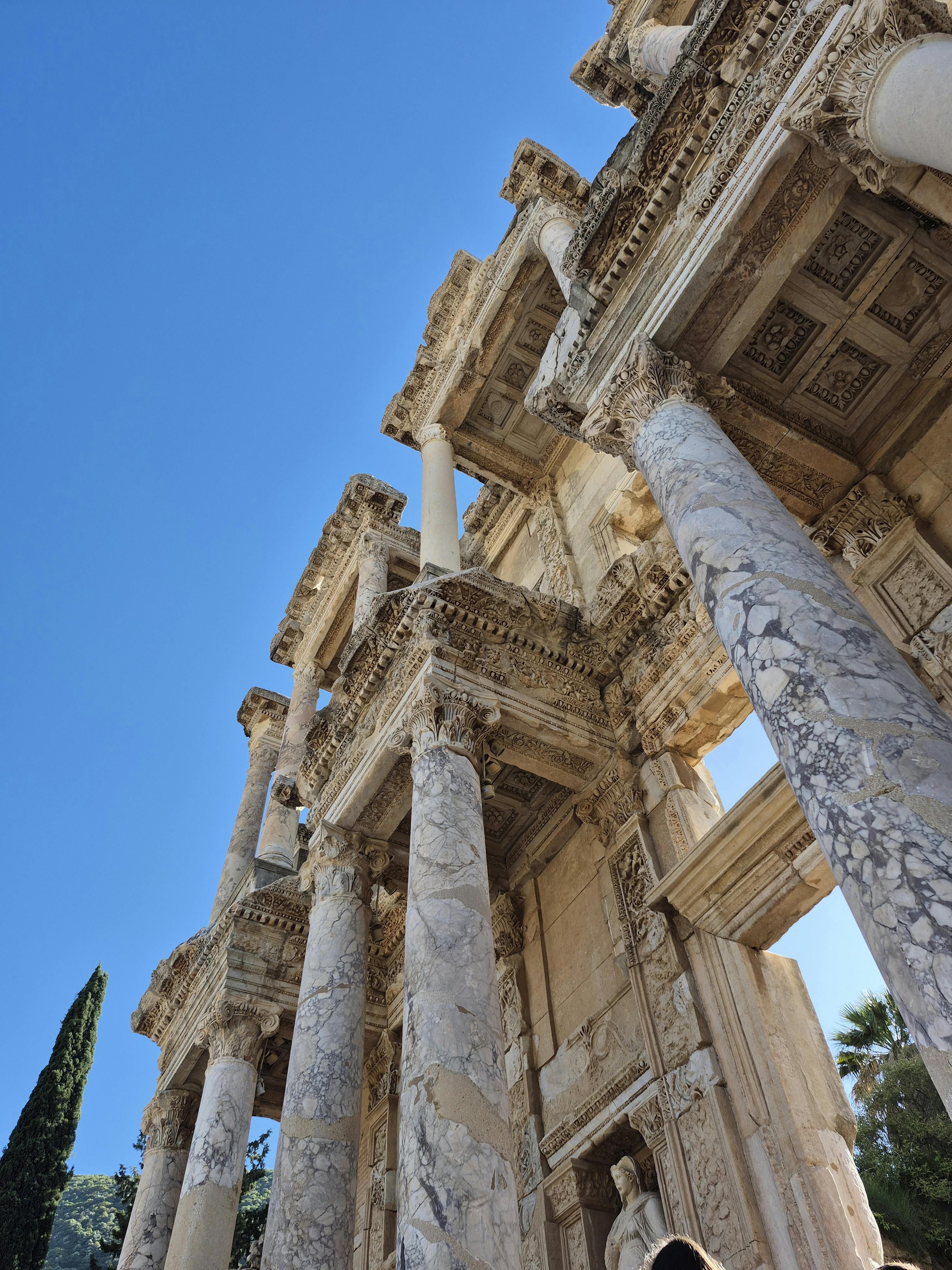 令人惊叹的景色，蔚蓝的天空映衬着古罗马图书馆废墟，展示了建筑细节