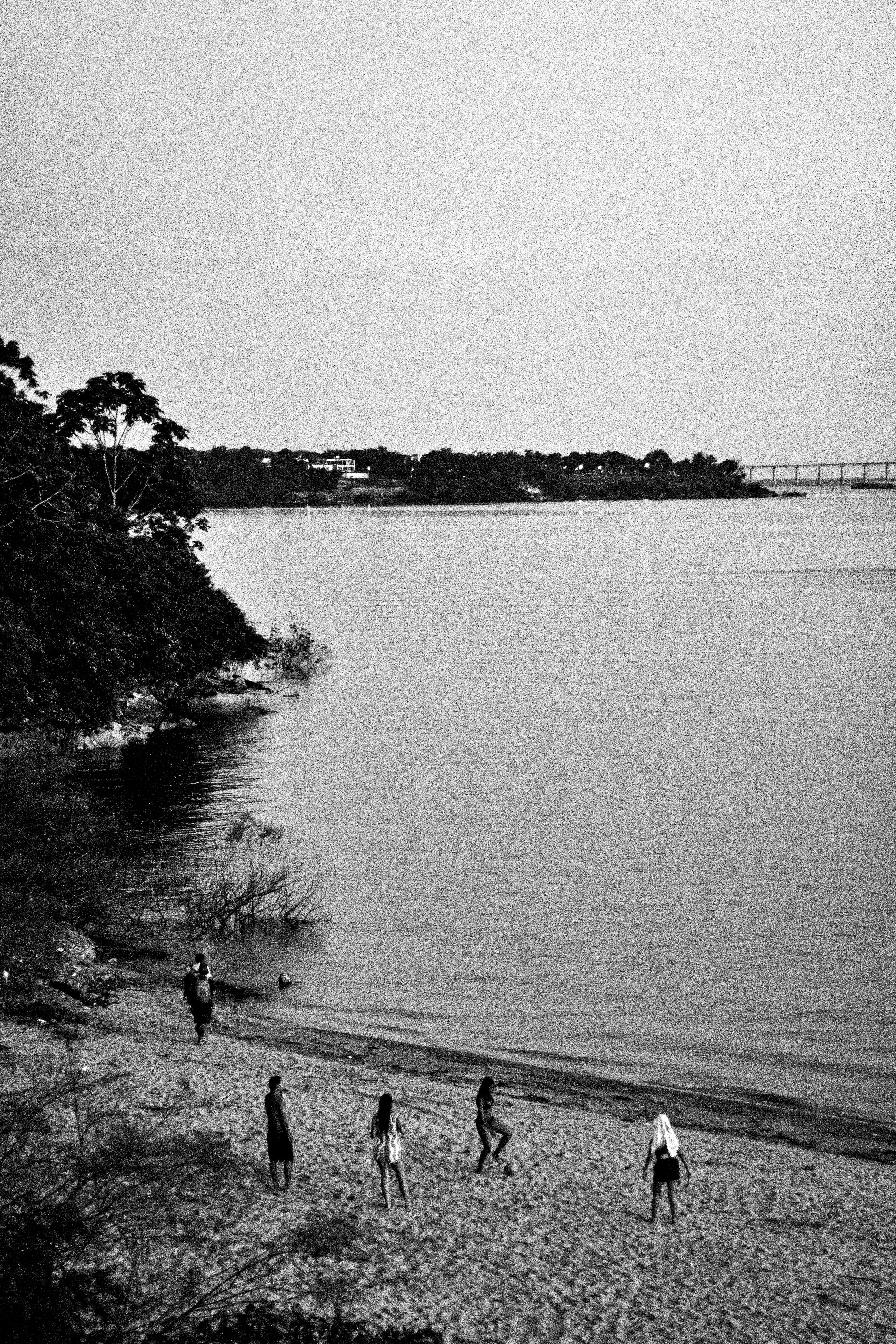 宁静的海滩场景中，黑色和白色的人正在岸边行走