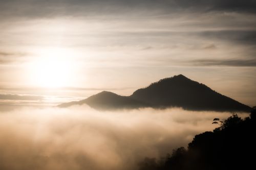Free Experience a serene sunrise over misty Bali mountains, capturing tranquility and beauty. Stock Photo