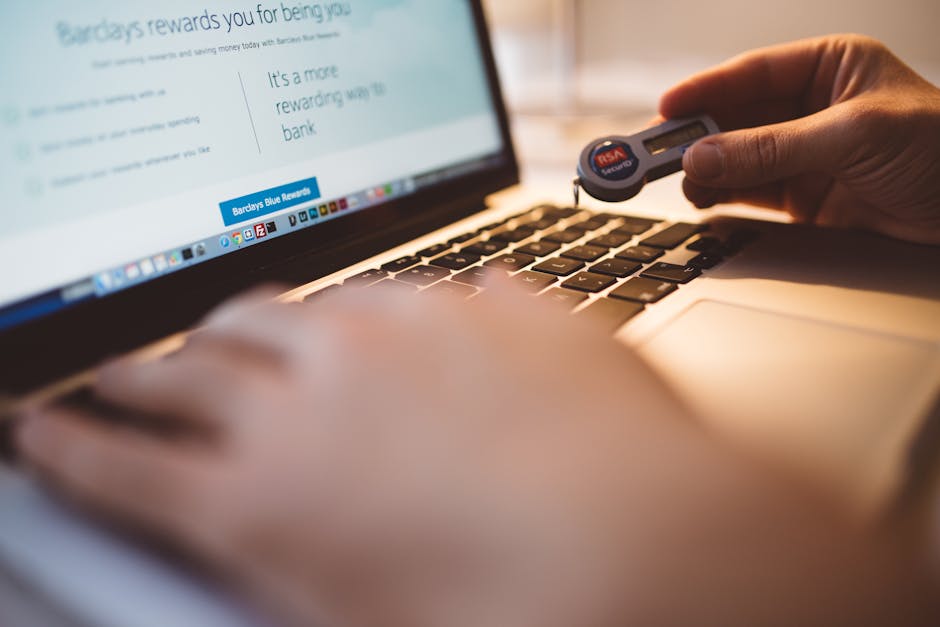 Person Holding Electronic Device While Using Its Macbook Laptop