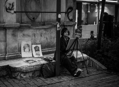 A street artist creates portraits in black and white on a bustling street in Istanbul.