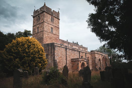 英国布兰西佩斯的哥特式教堂周围绿树成荫，天空阴沉