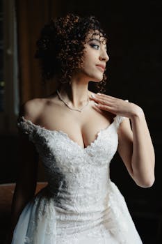 穿着蕾丝婚纱的美丽新娘在室内优雅地摆姿势