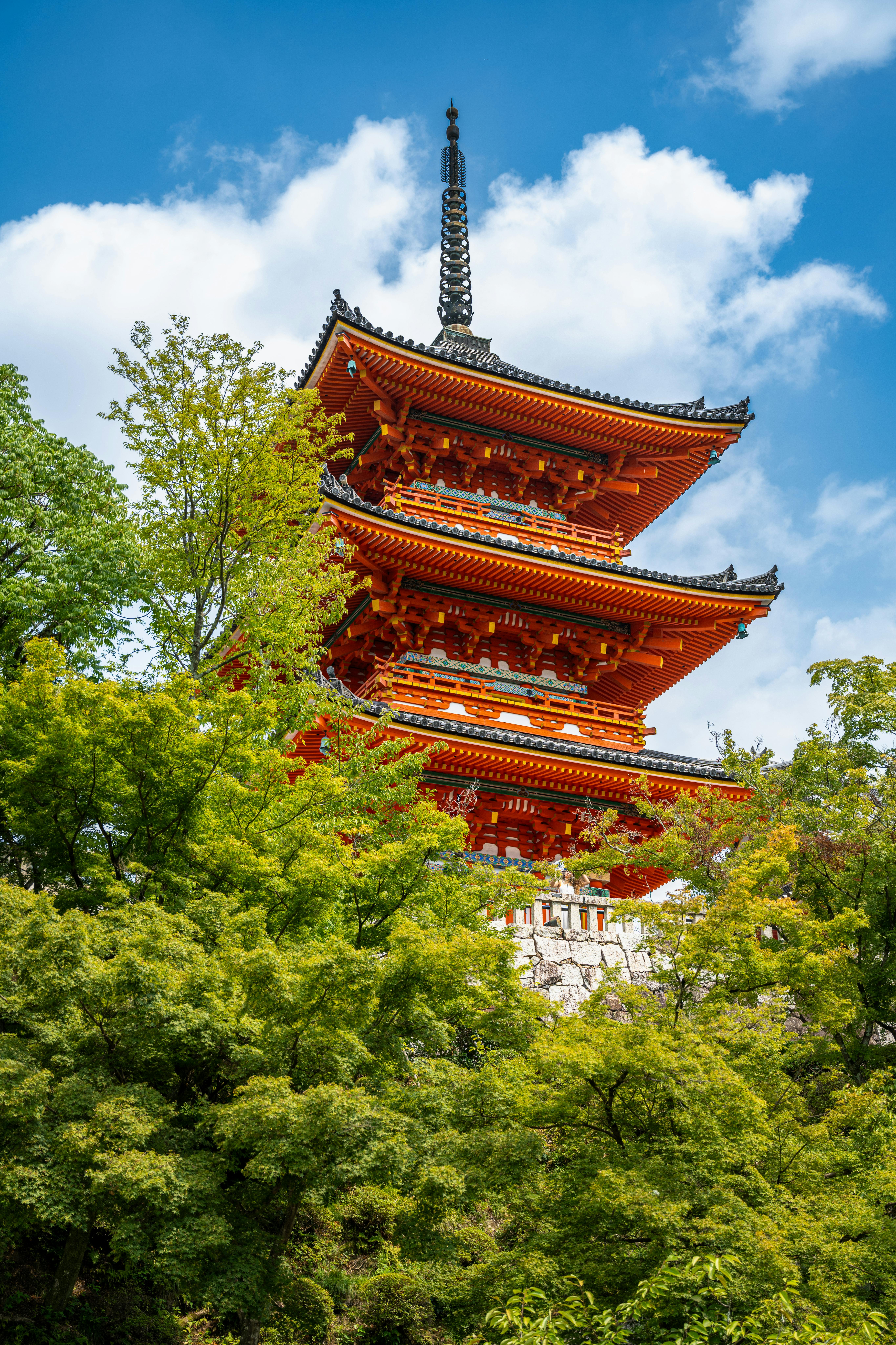 A beautiful pagoda at Kiyomizu-dera temple, surrounded by lush greenery in Kyoto, Japan.