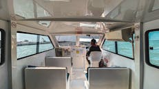 在船舱里，一个司机正在晴朗的海面上航行