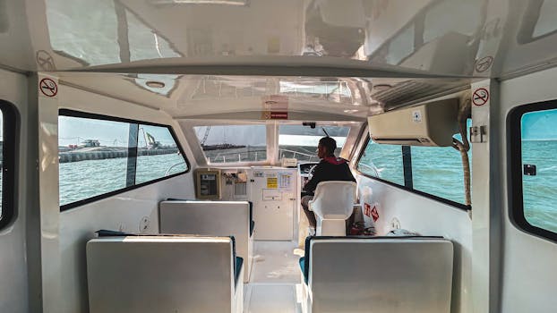 在船舱里，一个司机正在晴朗的海面上航行