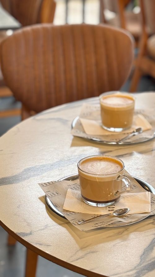 Free Two frothy cappuccinos on a marble cafe table, set for a cozy coffee break. Stock Photo