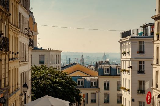 A picturesque view of a Parisian street with classic architecture and a charming rooftop cafe.