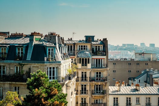 Scenic view of classic Parisian rooftops with a backdrop of the city skyline on a clear day.