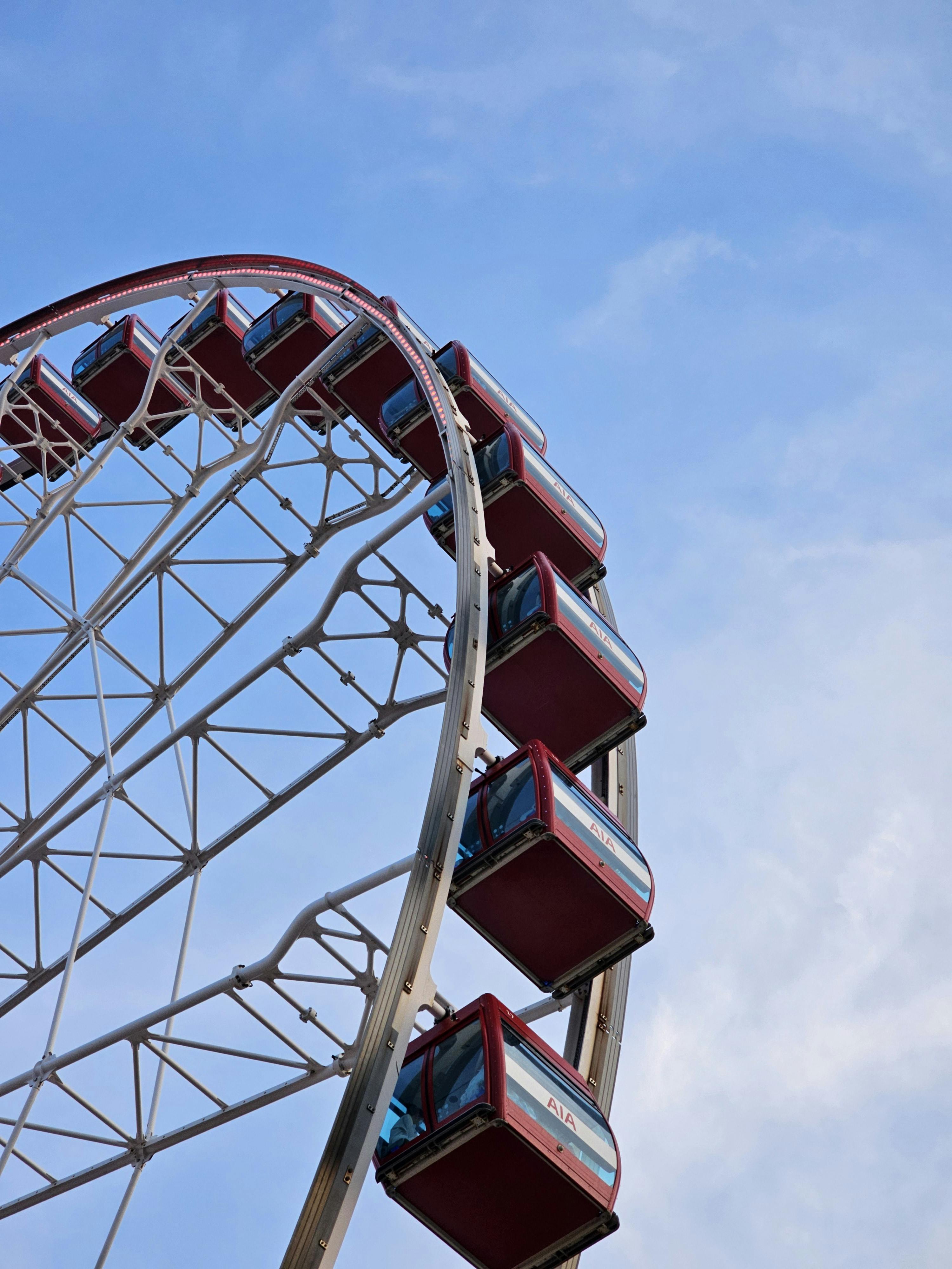 摩天轮上，红色客舱映衬着蓝天，捕捉到了休闲娱乐的精髓